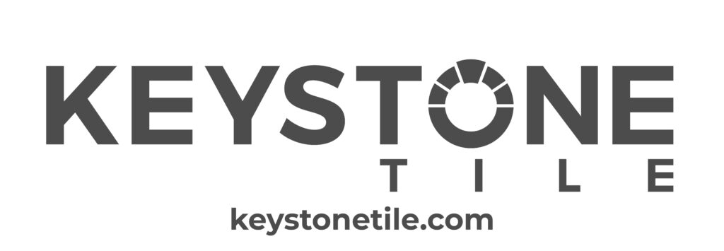 Logo of Keystone Tile with the text "KEYSTONE TILE" in bold capital letters. The "O" in "KEYSTONE" is designed with a geometric pattern. Below, the website "keystonetile.com" is displayed in smaller letters.